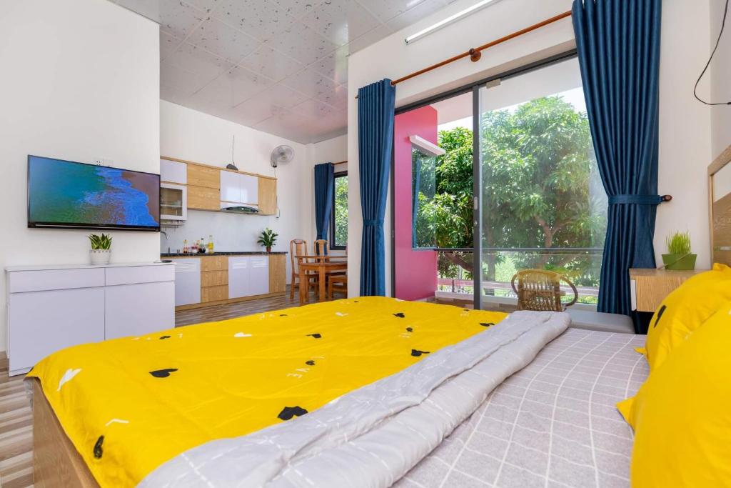 a large yellow bed in a room with a kitchen at MTV Homestay Vũng Tàu in Vung Tau