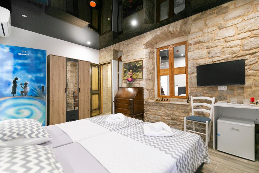 a bedroom with two beds and a stone wall at Rooms Royal in Stomorska