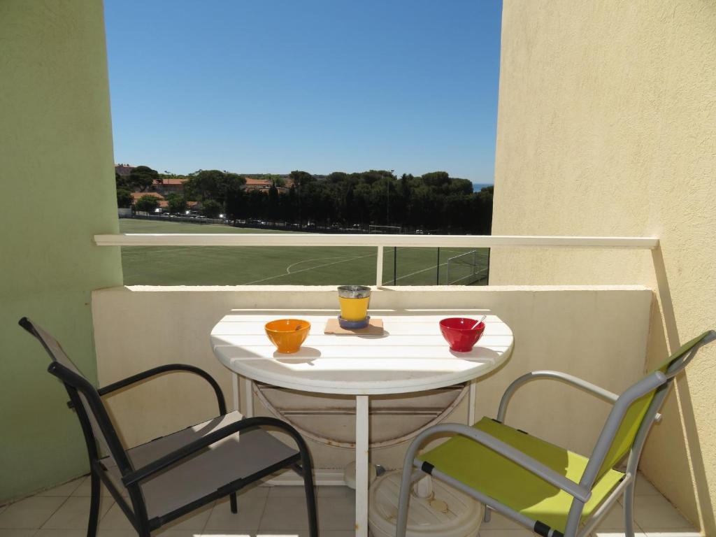 une table et des chaises sur un balcon avec une fenêtre dans l'établissement Charmant 2 pièces avec parking, tennis et loggia à 300m de la plage - FR-1-338-431, à Sète