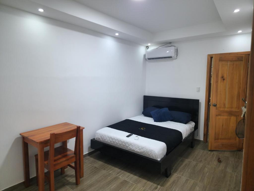 um quarto com uma cama e uma mesa de madeira em Costa Del Sol em Puerto Ayora