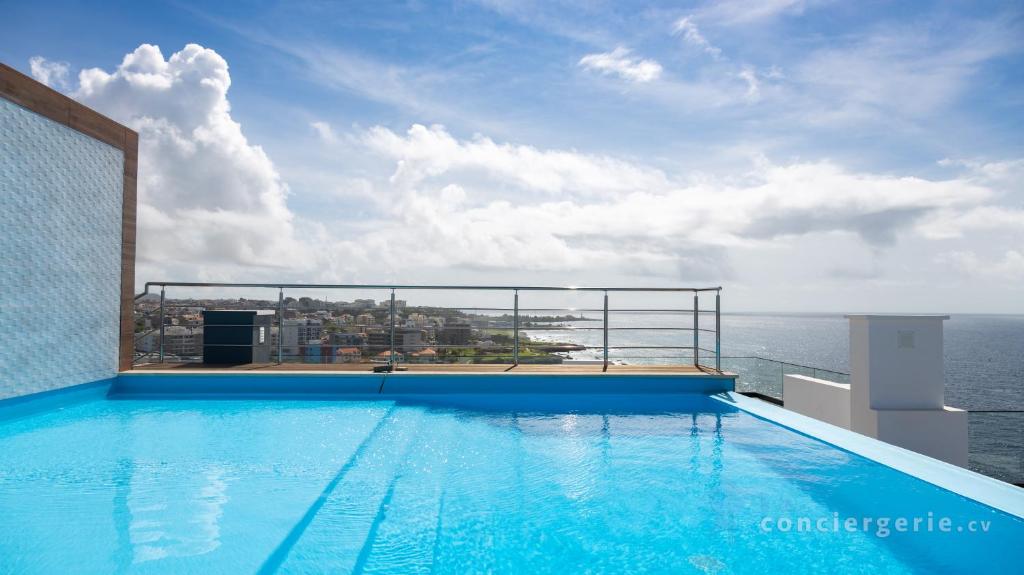 a swimming pool on top of a building with the ocean at 3 bdr aprt, stunning seaview, rooftop pool - LCGR in Praia