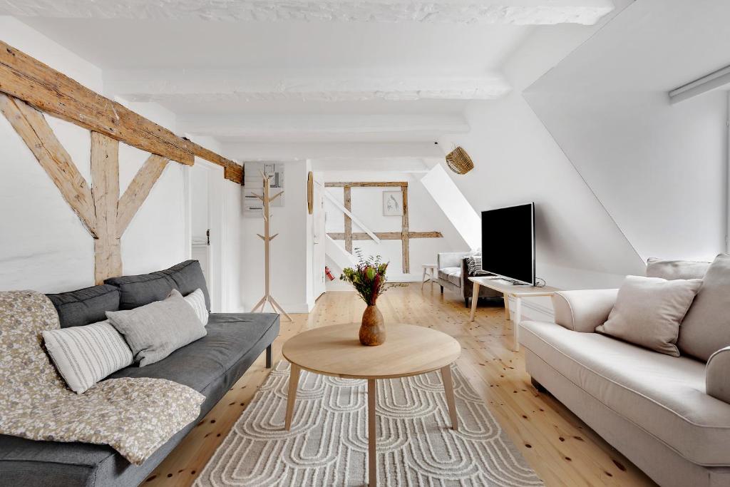 コペンハーゲンにあるSanders Penny - Charming Three-Bedroom Apartment in the Middle of Actionのリビングルーム(ソファ、テーブル付)