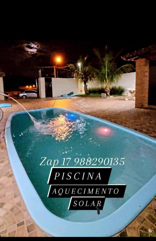 a sign in a swimming pool at night at Recanto Fernanda in Olímpia