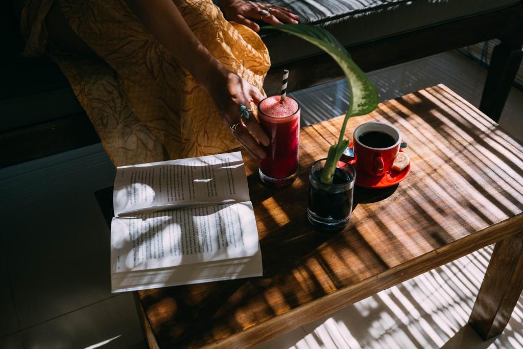 a table with two cups and a plant on it at Bale Sampan Boutique Bungalows in Gili Trawangan