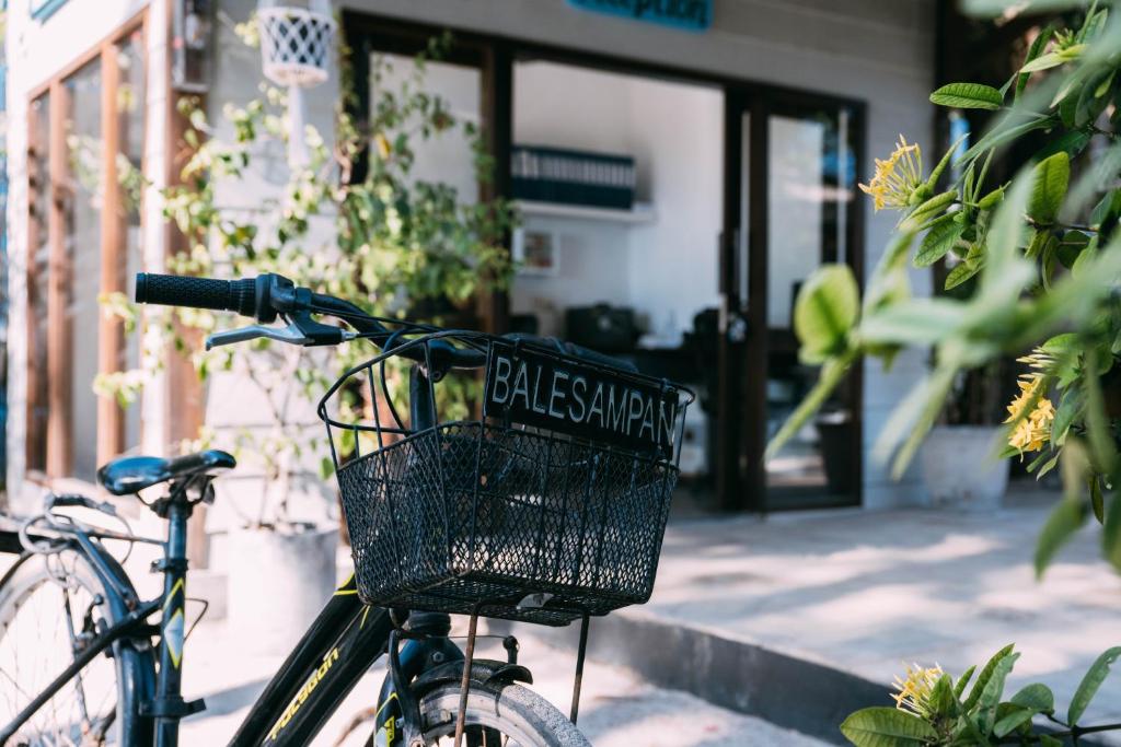 a bike with a basket parked in front of a building at Bale Sampan Boutique Bungalows in Gili Trawangan