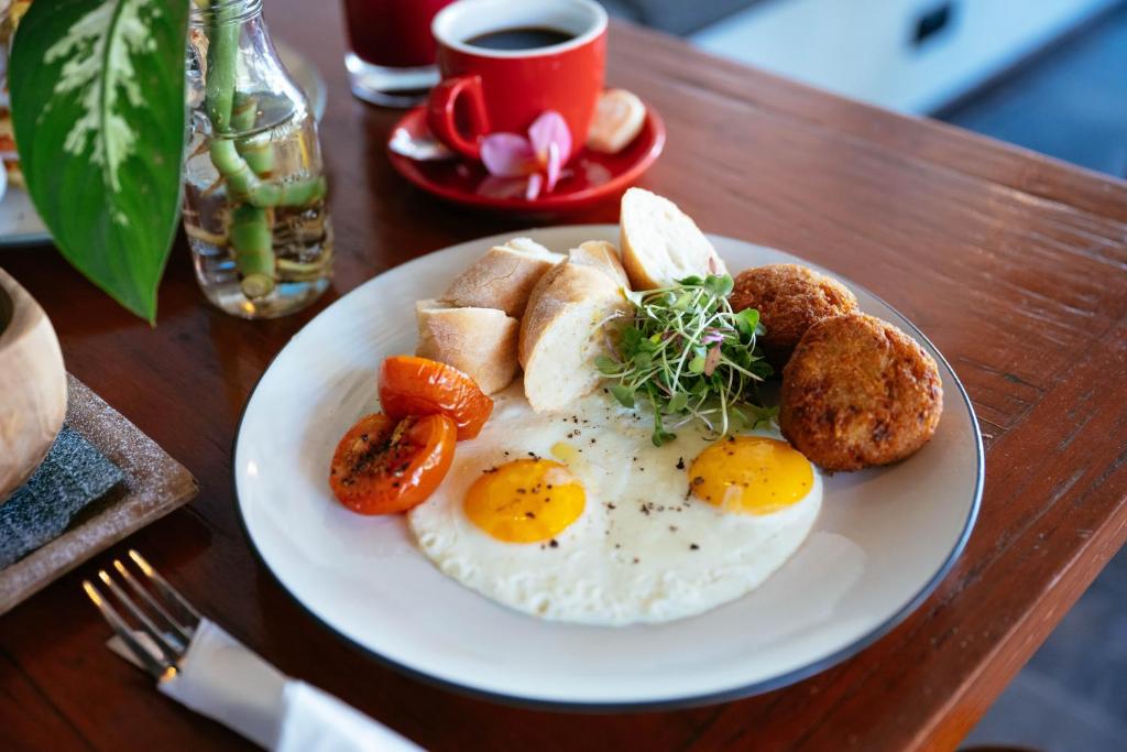 a plate of eggs and bread and a cup of coffee at Bale Sampan Boutique Bungalows in Gili Trawangan