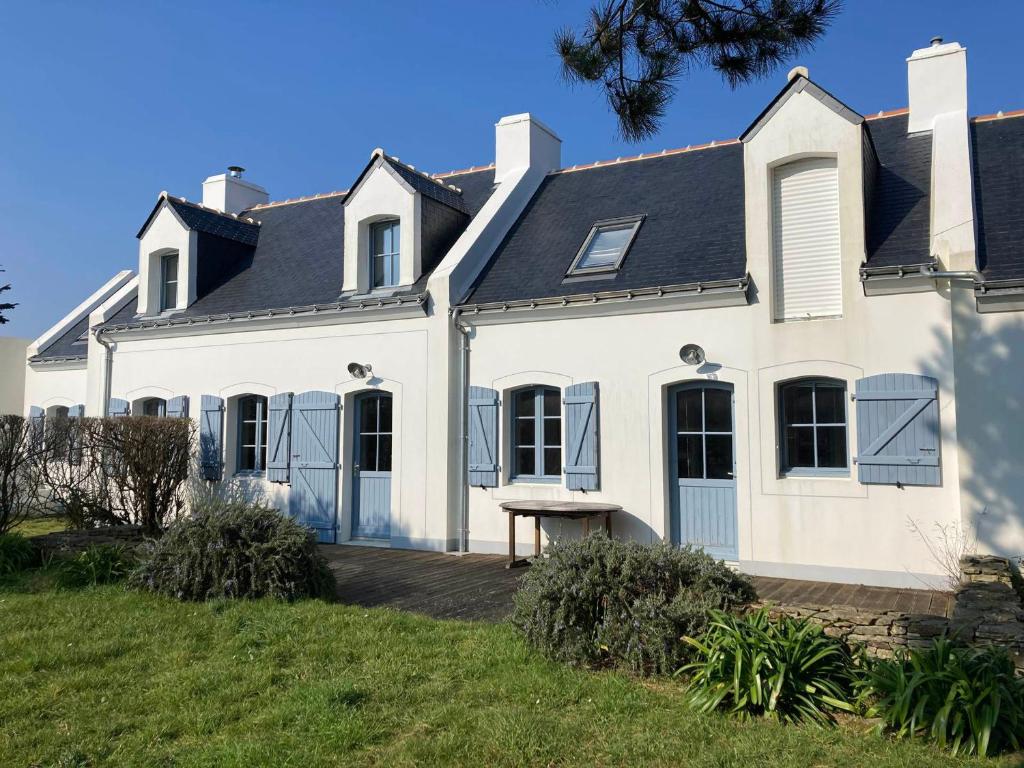 une maison blanche avec un toit noir dans l'établissement Belle maison à 600m de la mer, jardin, terrasse et tout confort à Bangor - FR-1-418-228, à Bangor