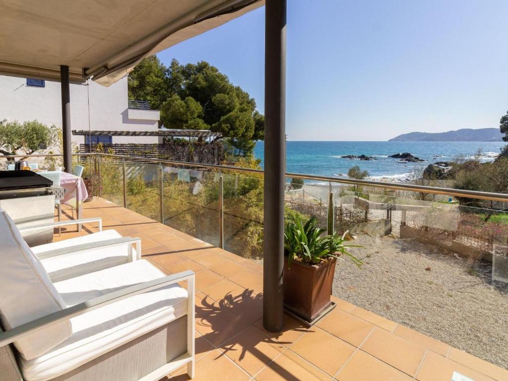 einen Balkon mit weißen Stühlen und Meerblick in der Unterkunft Apartamento de lujo frente al mar en Playa de la Tonyines, 3 habitaciones, terraza, garaje y más - ES-228-127 in Llança