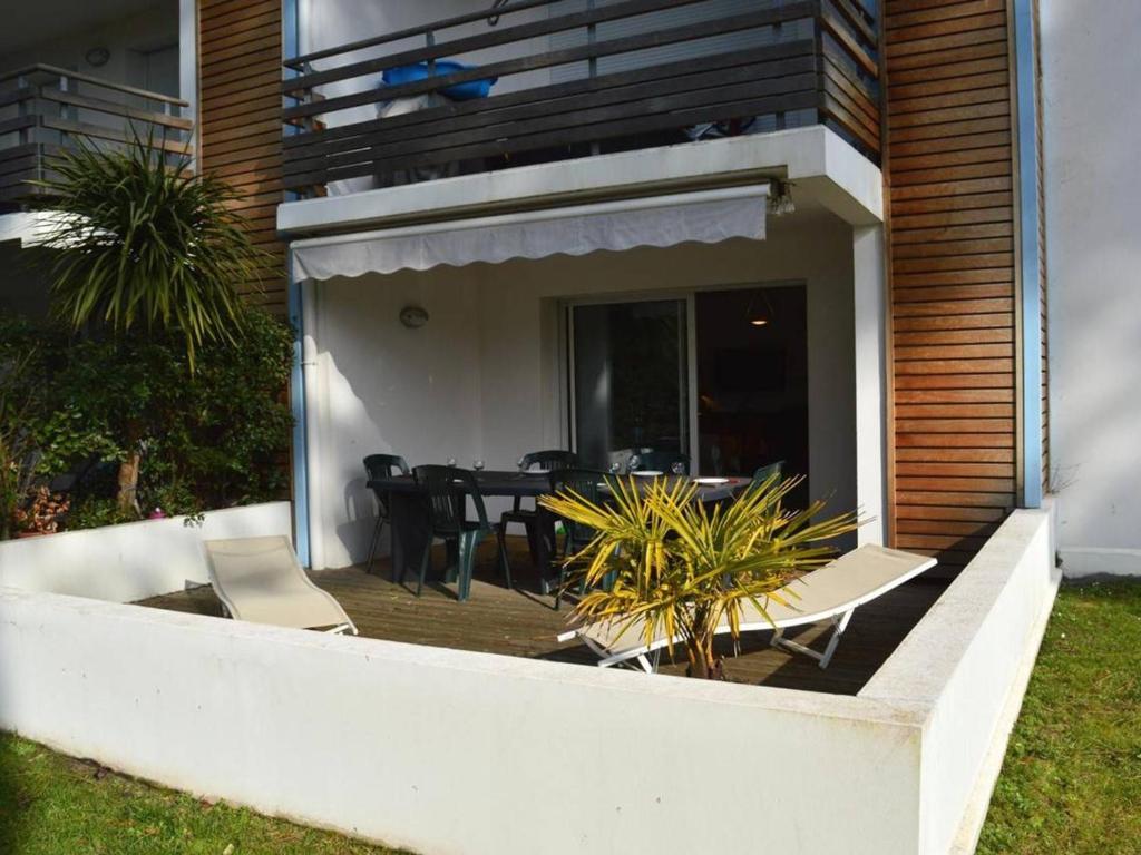une maison avec un patio avec une table et des chaises dans l'établissement Appartement avec Terrasse à Capbreton - Plages et Commerces à Proximité - FR-1-239-886, à Capbreton