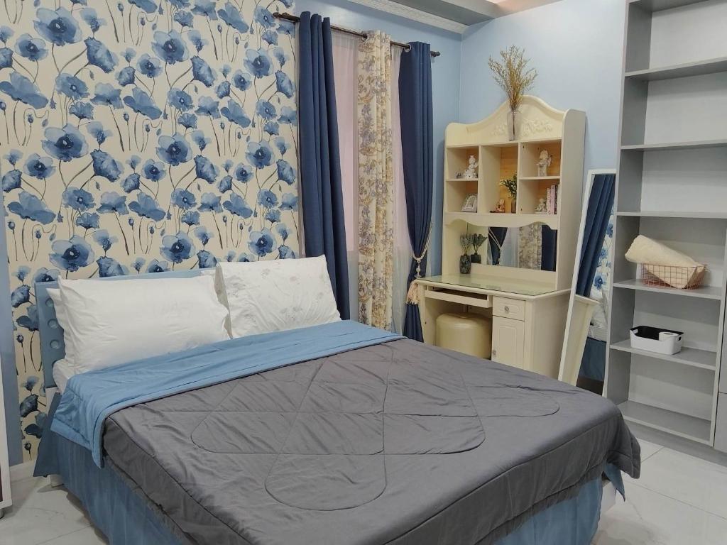 een slaapkamer met een bed en een blauwe en witte muur bij Quirino hub 2 BR family room in Davao City