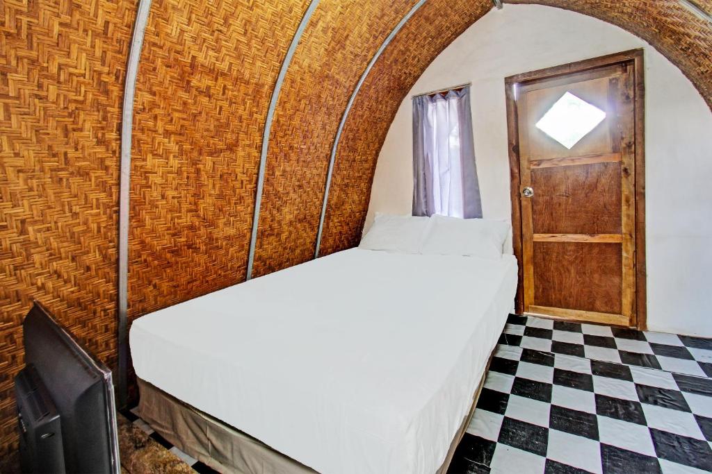 a bedroom with a bed and a checkered floor at OYO 92354 Samalas Syariah Homestay in Labuan Lombok