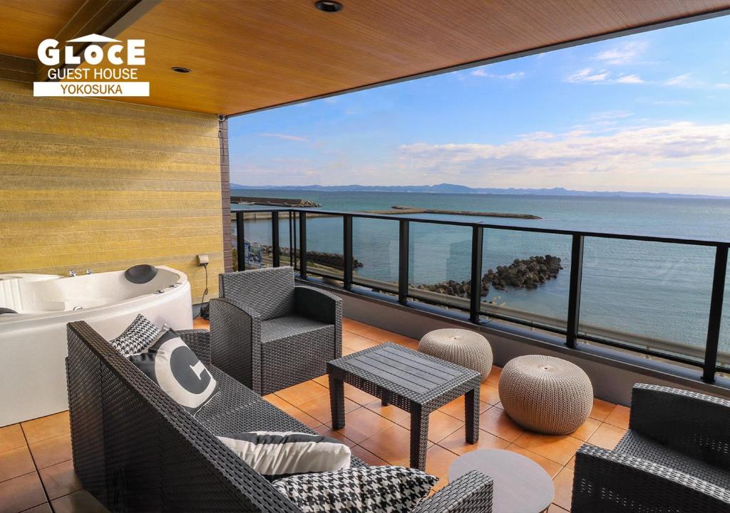a balcony with chairs and a tub and a view of the ocean at GLOCE ル グランブリュリゾート長沢 l テラスでゆったりオーシャンビュージャグジー 1棟貸し切り 小型犬可 無料駐車場付 in Kōembō