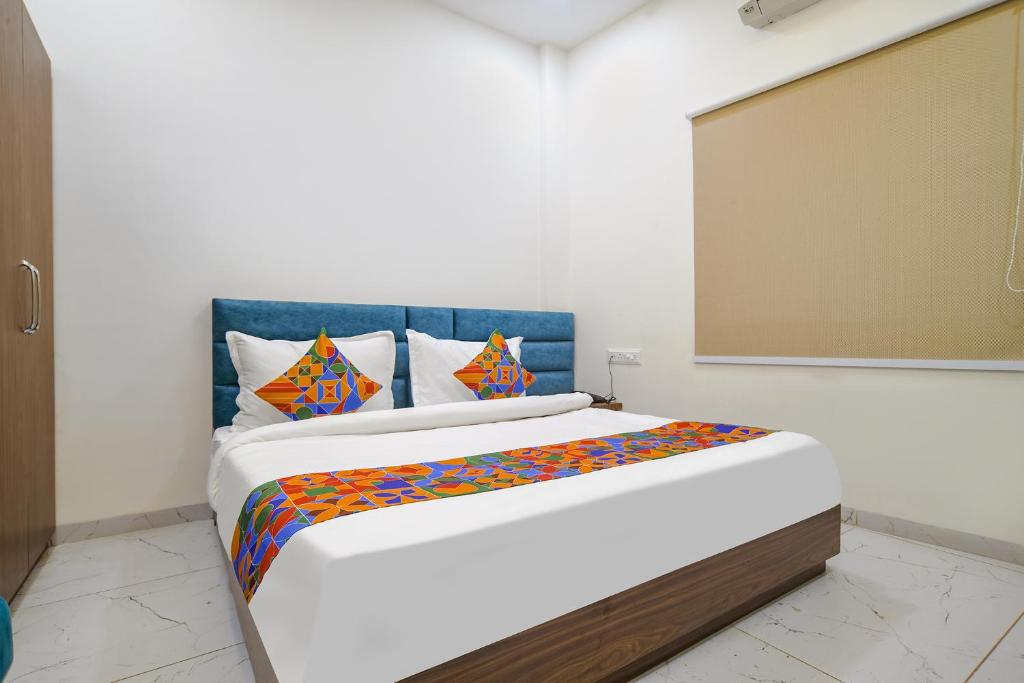 a bedroom with a large bed with colorful sheets at FabHotel Ramya in Indore
