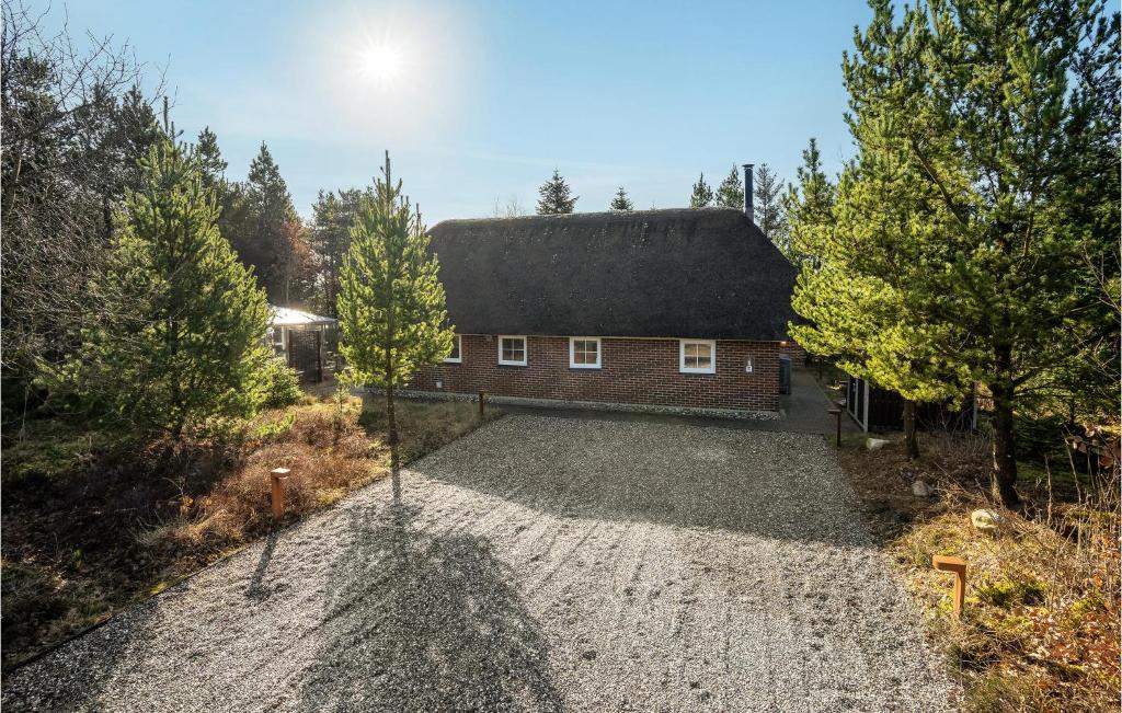 uma casa com um telhado preto numa calçada de cascalho em 3 Bedroom Beautiful Home In Nrre Nebel em Nørre Nebel