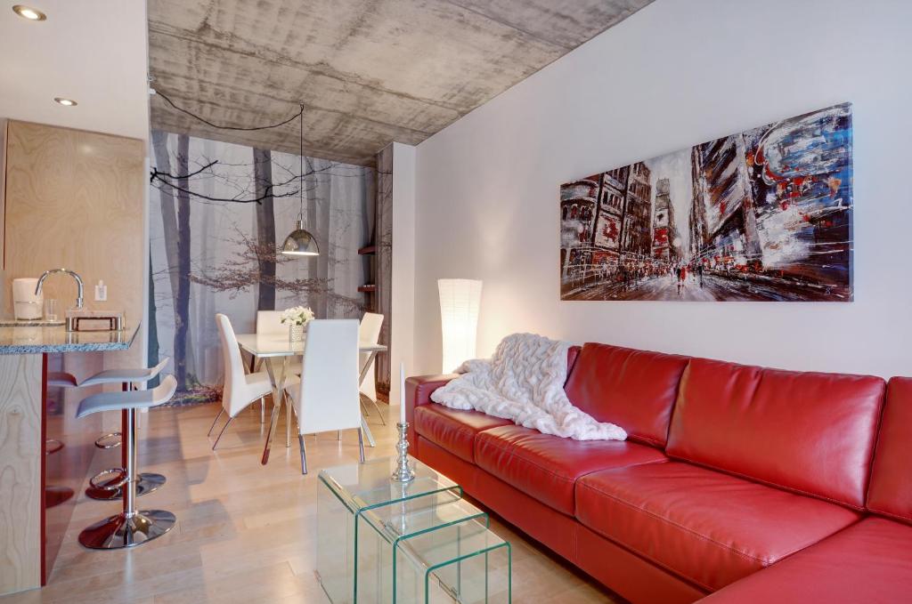 sala de estar con sofá rojo y mesa en Les Immeubles Charlevoix - Le 760204 en Quebec