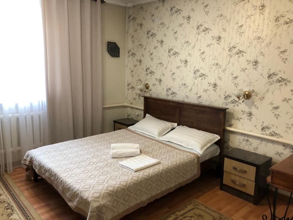 ein Schlafzimmer mit einem Bett mit zwei Handtüchern darauf in der Unterkunft Homestay JAISEL in Bischkek