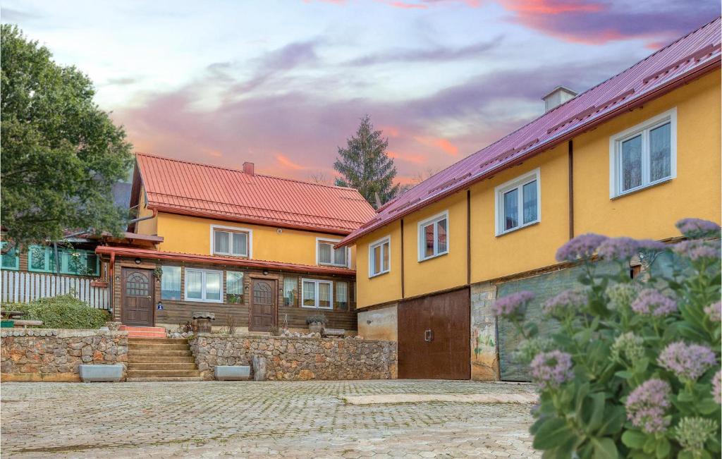 una casa amarilla con una pared de piedra en Amazing Home In Skare With Indoor Swimming Pool, 