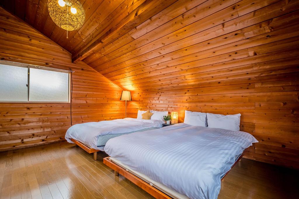 a bedroom with two beds in a wooden room at Stella Rental Villa Engawa House in Fujikawaguchiko