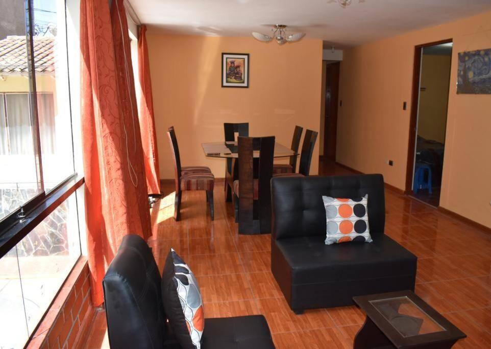 a living room with a black chair and a table at Departamento excelente ubicación in Cusco