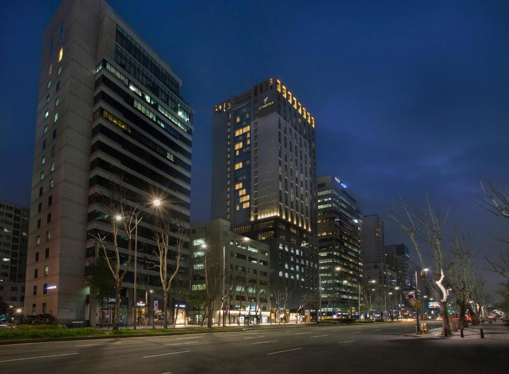 a city street at night with tall buildings at L7 Gangnam in Seoul