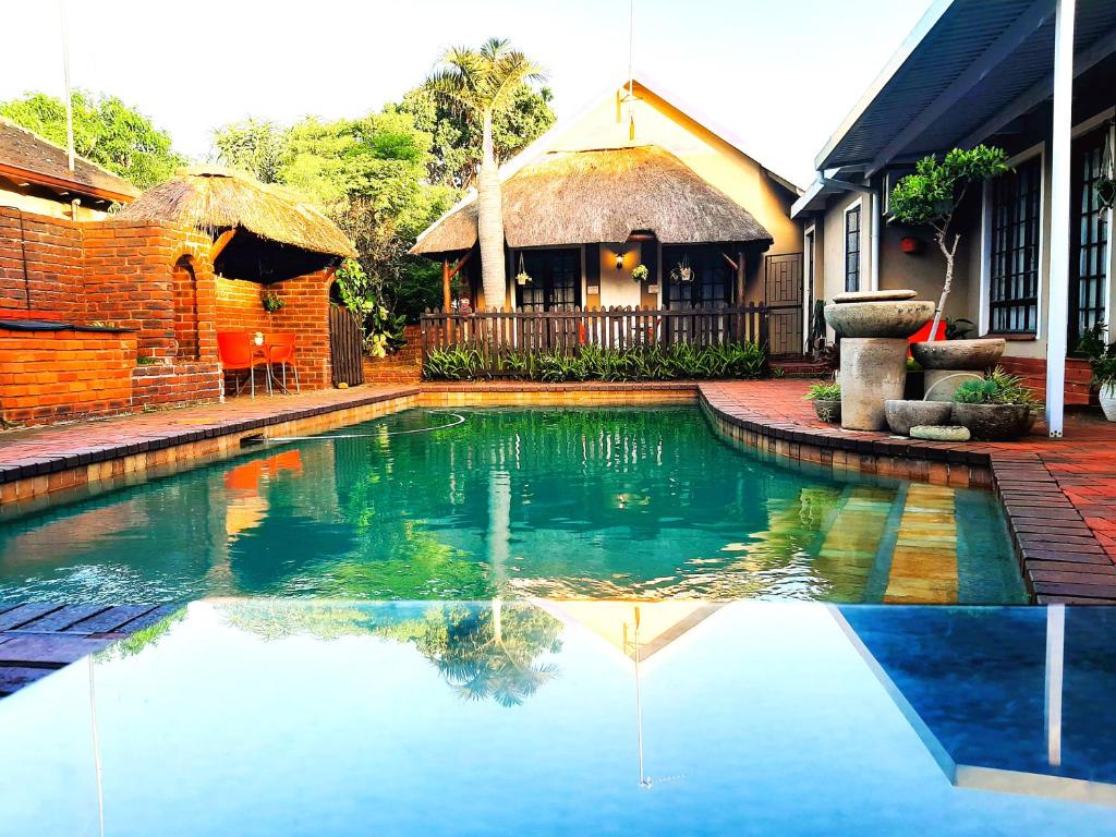 una piscina frente a una casa en Old Mill Guest House en Durban