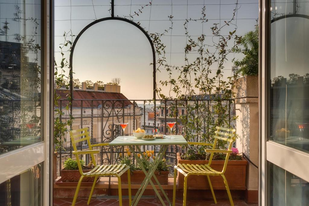 a patio with a table and chairs on a balcony at Tritone Top House in Rome