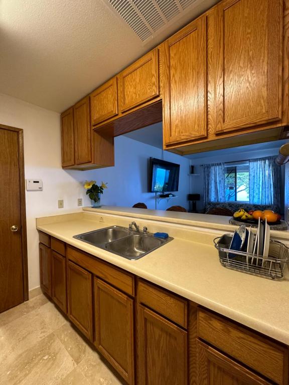 a kitchen with a sink and wooden cabinets at Kona Joe Coffee Farm in Kealakekua