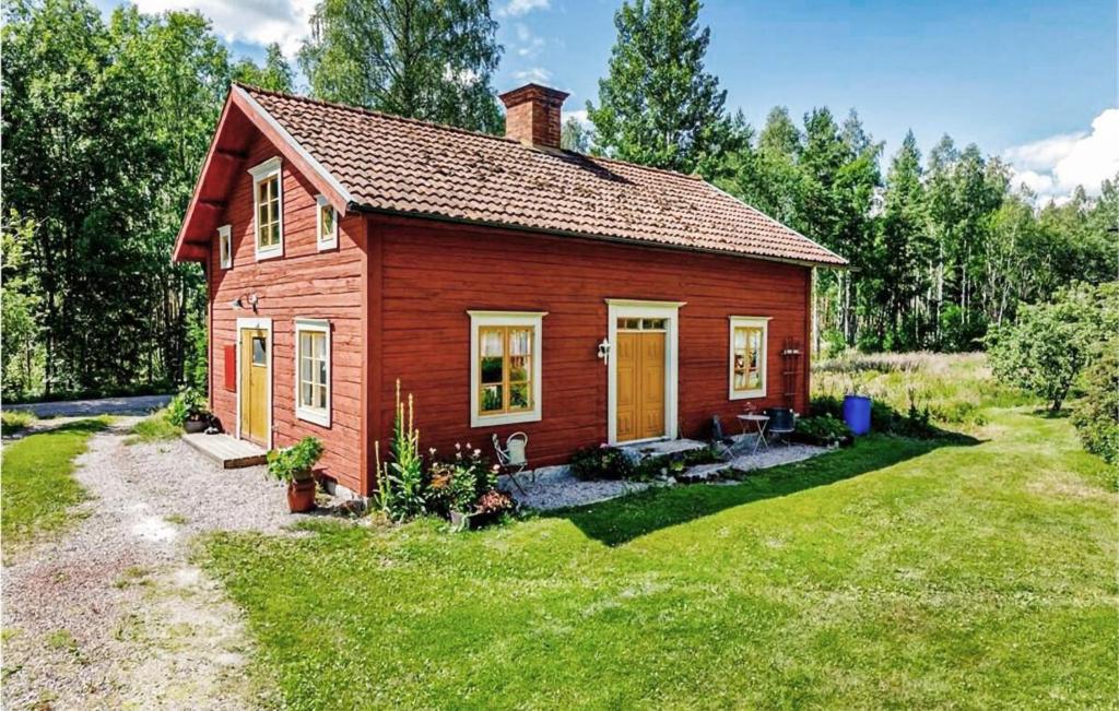 ein kleines rotes Haus mit einem Rasenplatz in der Unterkunft 1 Bedroom Stunning Home In Sala in Sala
