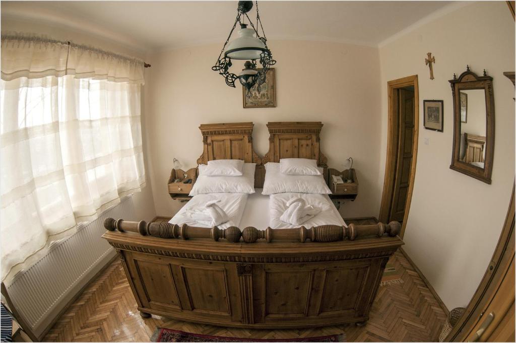 um quarto com uma cama grande e almofadas brancas em Szent Gellért Borház és Vendégfogadó em Makó