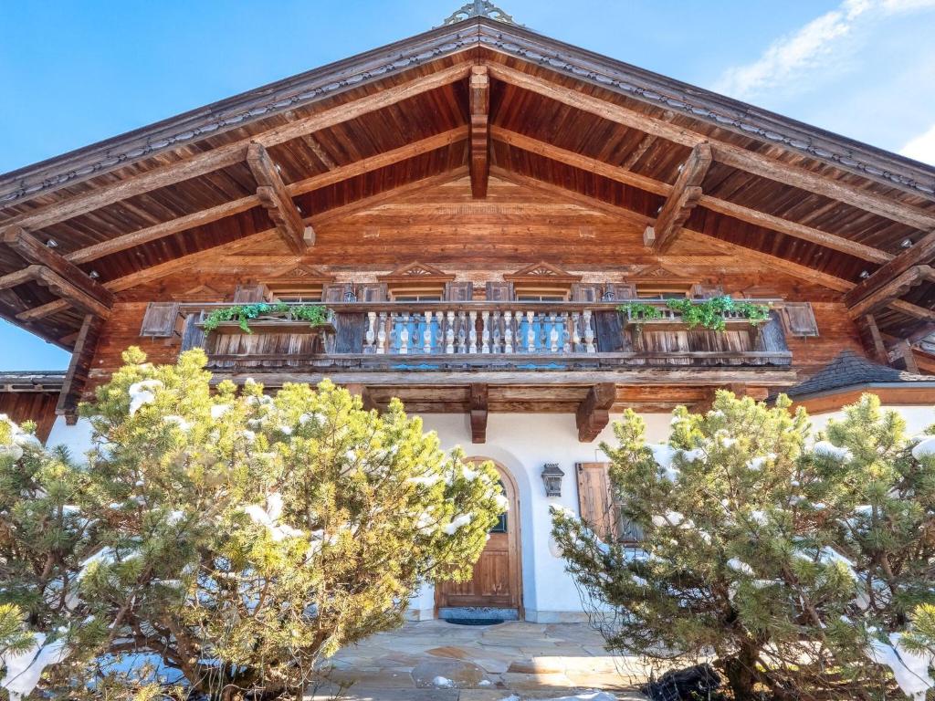 uma casa com um telhado de madeira e uma varanda em Luxurious chalet in St Johann in Tirol near Kitzbühel em Apfeldorf