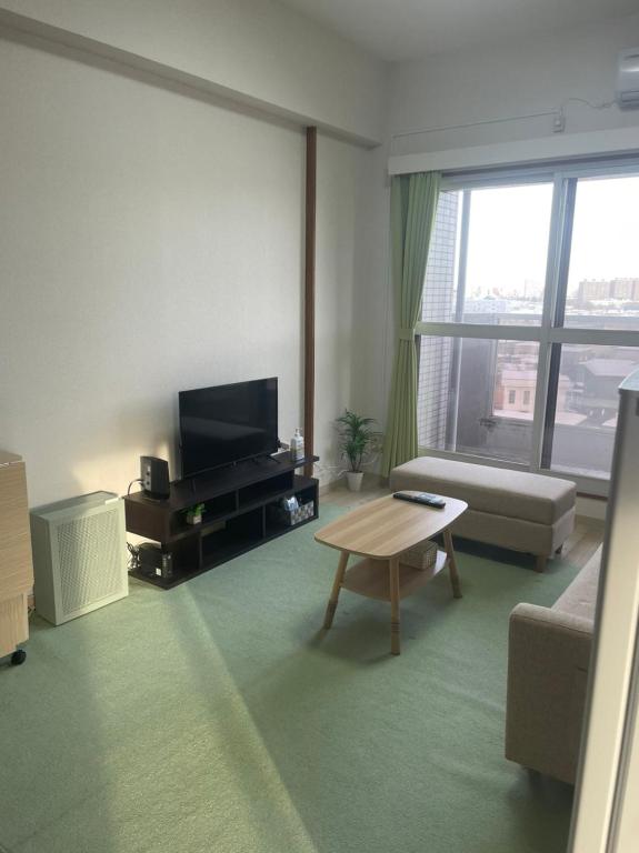 a living room with a tv and a coffee table at 500mfrom Sta first internet cozy in Shin-kotoni
