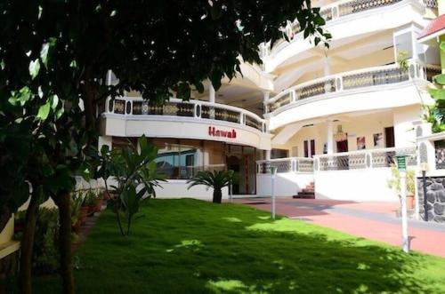 a large building with a lawn in front of it at Hawah Beach Resort Kovalom in Kovalam