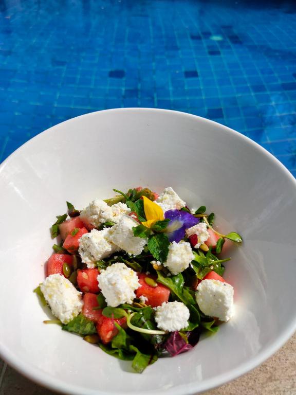a salad in a white plate on a table at Bale Sampan Boutique Bungalows in Gili Trawangan