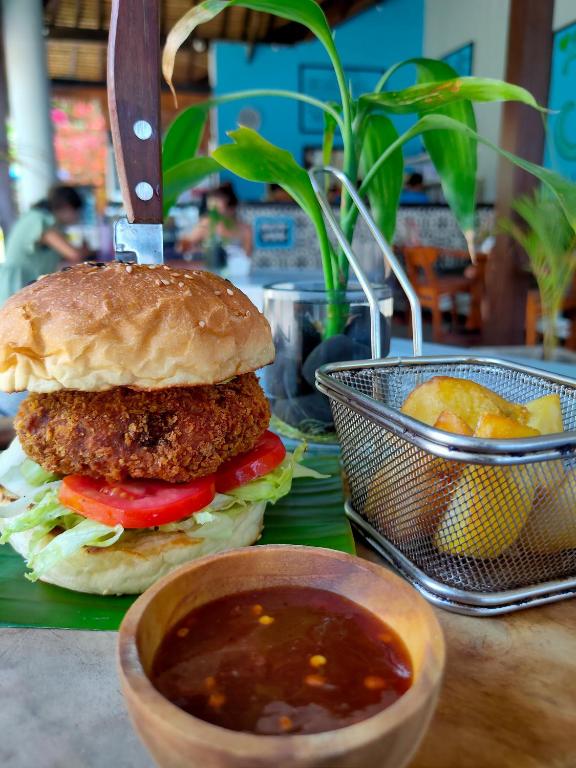 a sandwich on a bun with a bowl of soup at Bale Sampan Boutique Bungalows in Gili Trawangan