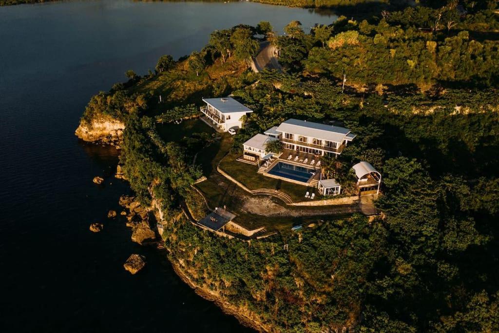 an aerial view of a house on an island in the water at Exclusive Cliff House with Pool and Beach Access in Dumanjug