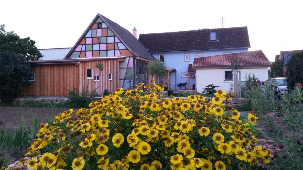 a bunch of yellow flowers in front of a house at Ferienhaus Kimmelsbacher Hof - Sauna & Naturpool in Bundorf