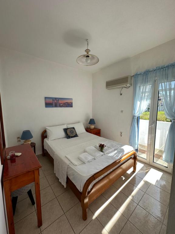 a bedroom with a bed and a table and a window at 2 Ambelia paradise in Megalochori