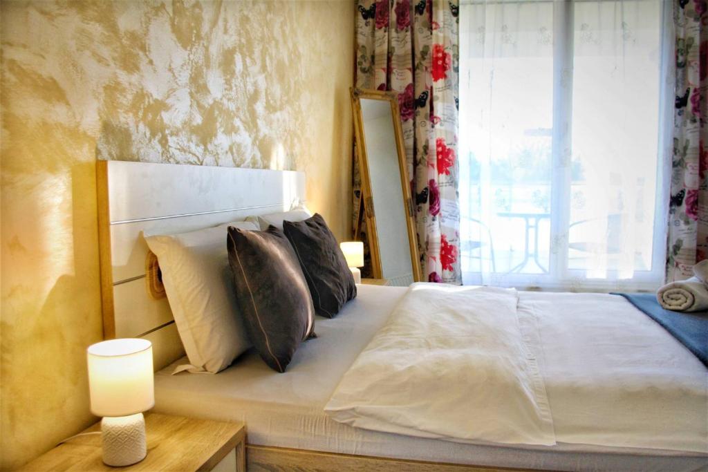 - une chambre avec un lit blanc avec des oreillers et une fenêtre dans l'établissement Home by Vibe, à Cluj-Napoca