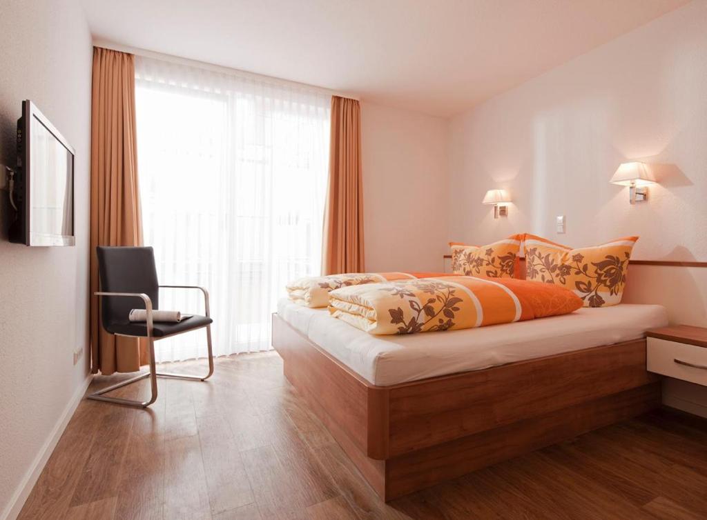 una habitación de hotel con una cama y una silla en Exquisit 4, en Norderney