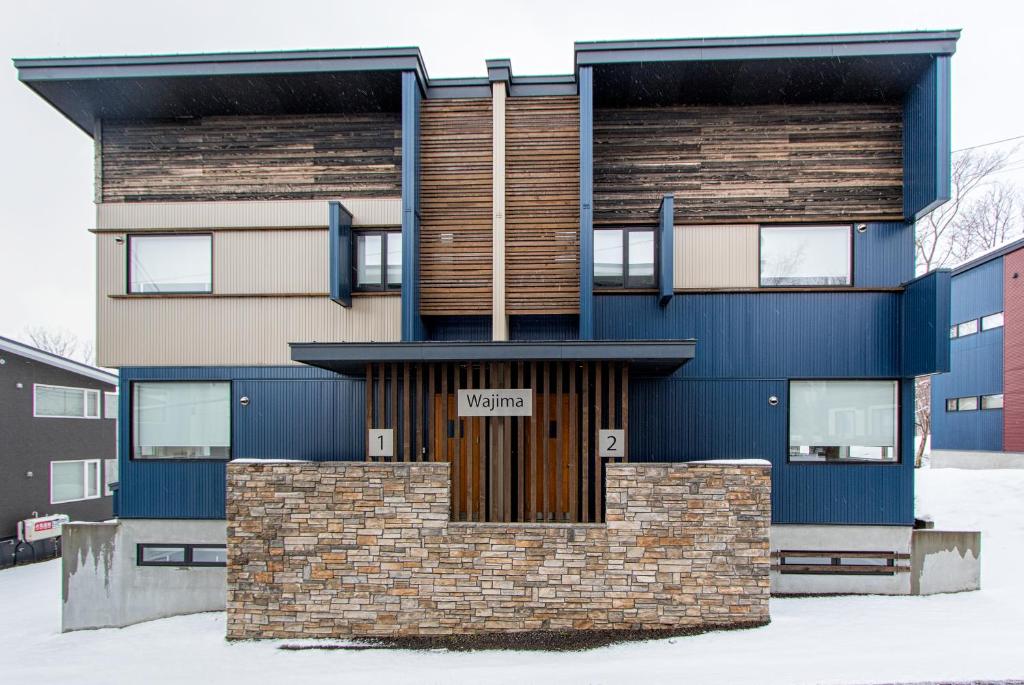 a blue building with a sign in front of it at Wajima Niseko in Niseko