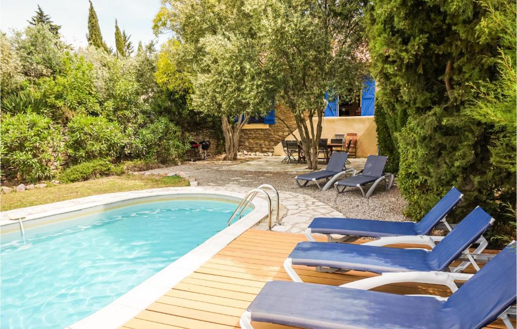 uma piscina com espreguiçadeiras, um deque e uma piscina em Stunning Home In Siran With Kitchen em Siran