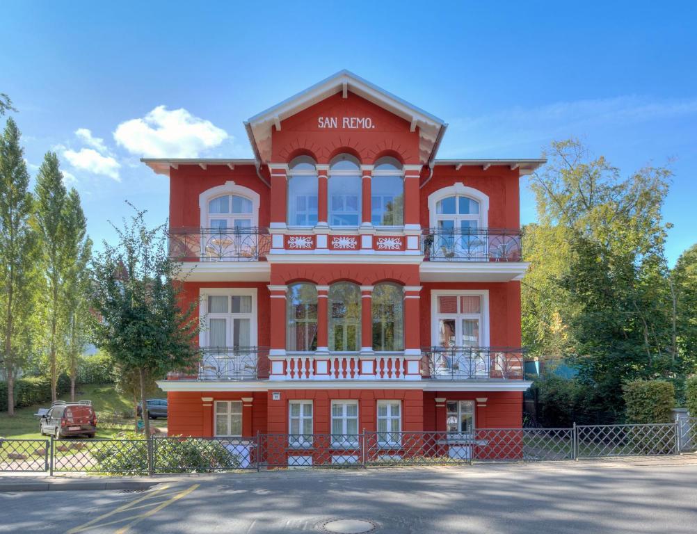ein rotes Gebäude mit einem Schild darauf in der Unterkunft Villa San Remo in Heringsdorf