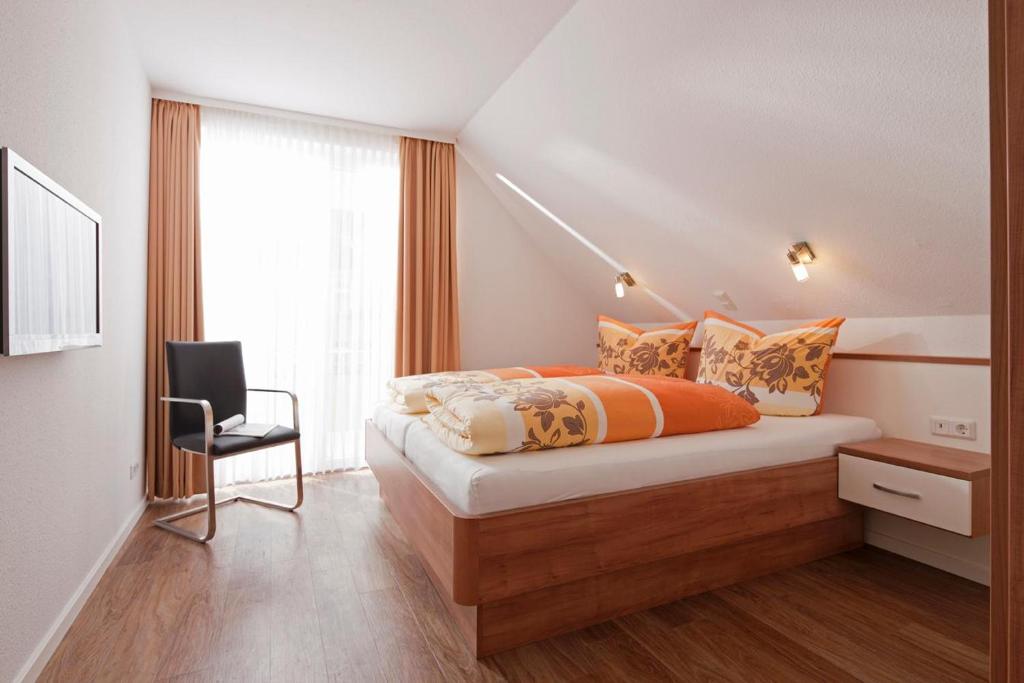 1 dormitorio con 1 cama con silla y ventana en Exquisit 6, en Norderney