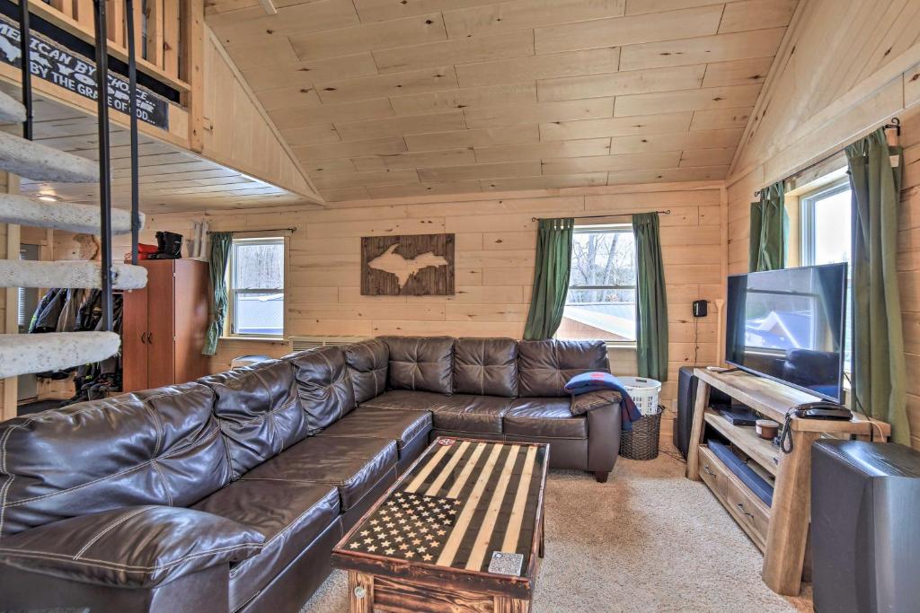 salon ze skórzaną kanapą i telewizorem w obiekcie Manistique Cabin with Grill - Near Thunder Lake w mieście Steuben