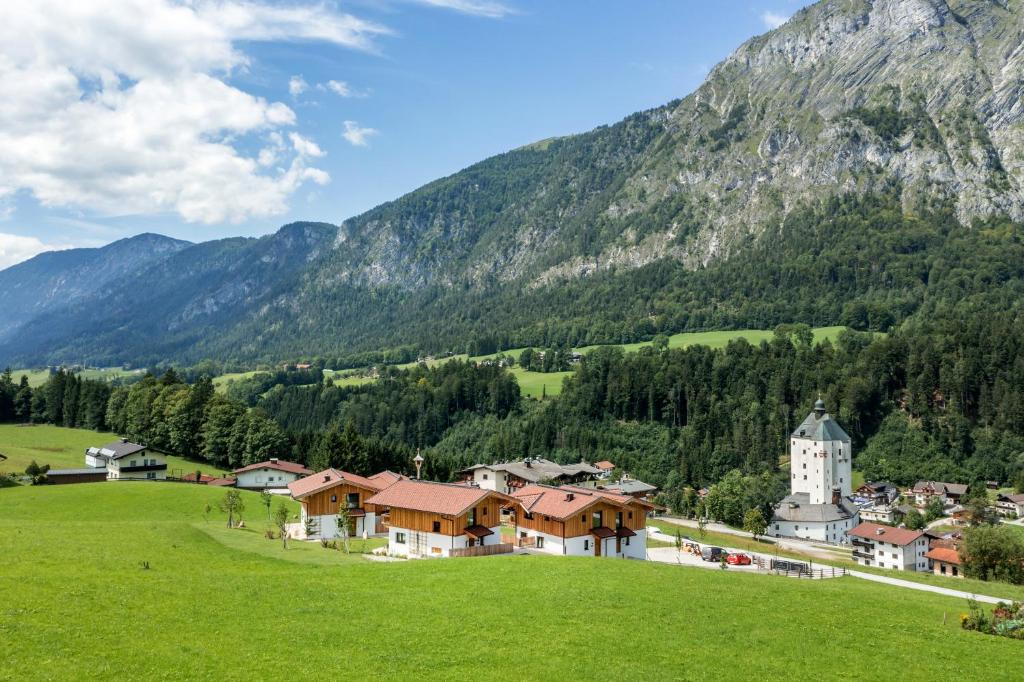 un pueblo en una colina con una iglesia y montañas en Chalets Weitblick Mariasteinerhof en Mariastein