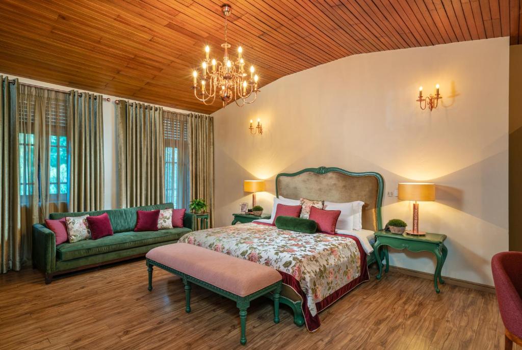 a bedroom with a bed and a couch at Clove Villa in Kandy