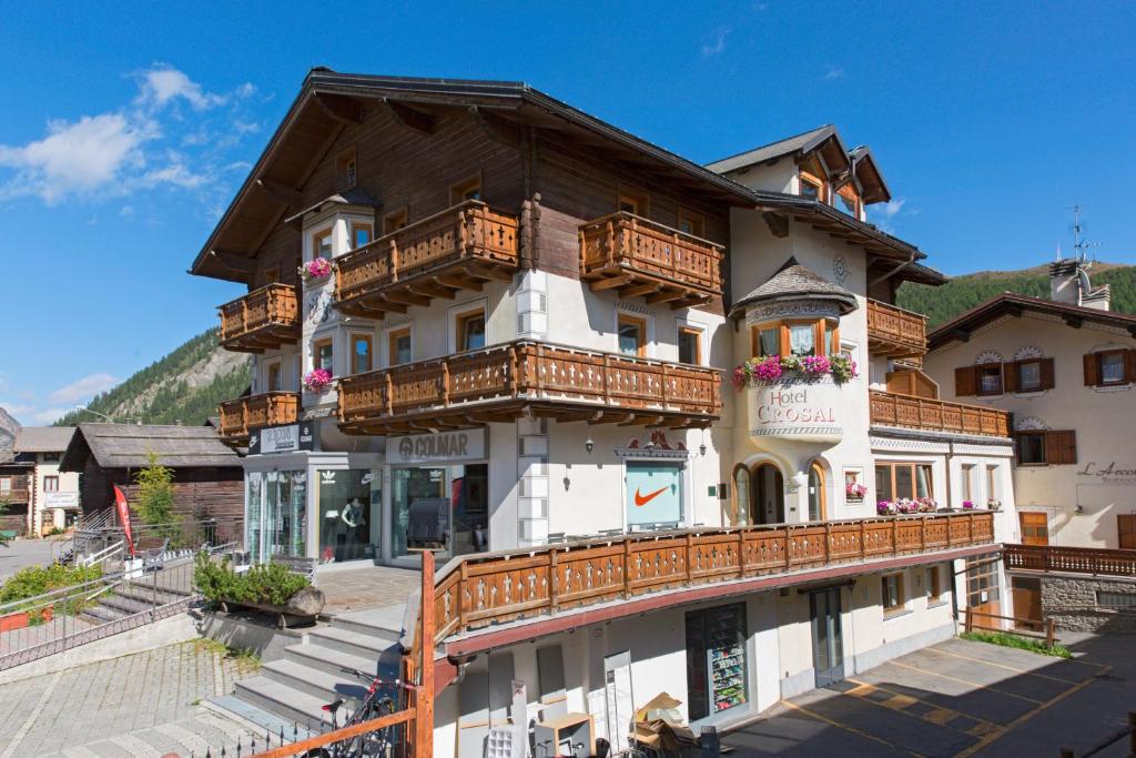 a building with wooden balconies on the side of it at Hotel Crosal in Livigno