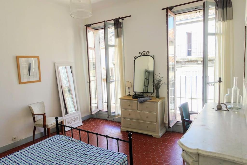 een slaapkamer met een bed en een dressoir met een spiegel bij Tout le charme de l'ancien marseillais in Marseille