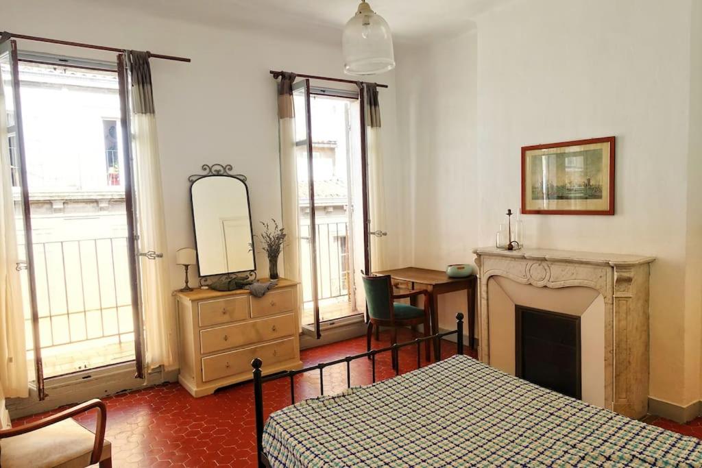 a bedroom with a bed and a fireplace and a mirror at Tout le charme de l&#39;ancien marseillais in Marseille