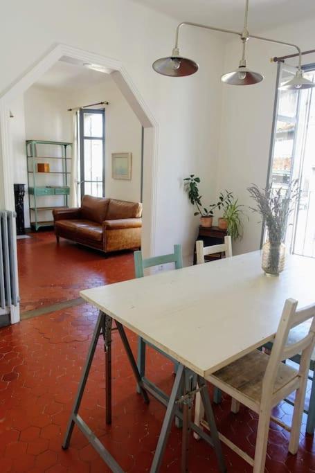 a living room with a white table and chairs at Tout le charme de l&#39;ancien marseillais in Marseille